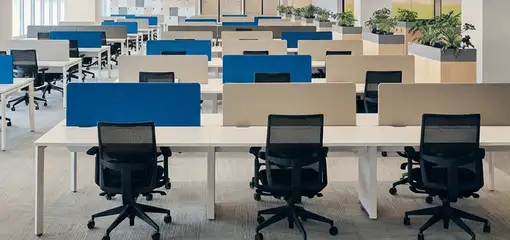 Modern open-plan office space featuring clean workstations, ergonomic chairs, and sanitized carpets provided by professional office cleaning services in Syracuse, NY.